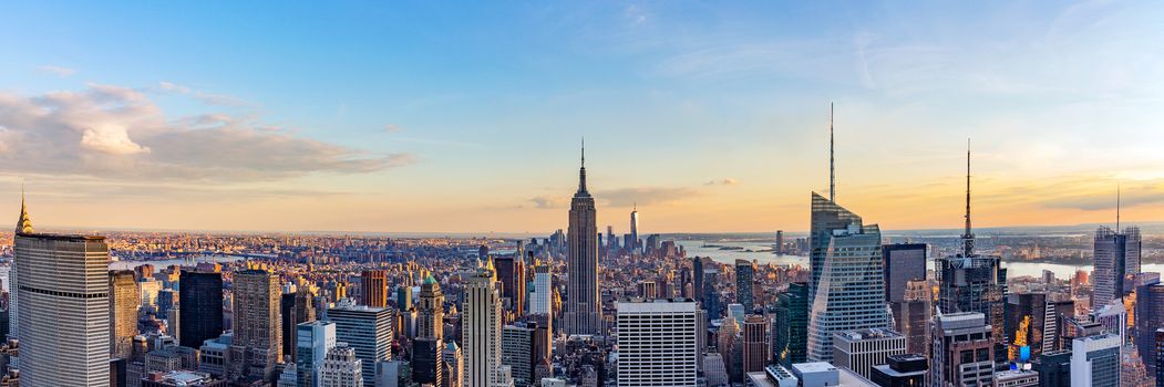 New York City skyline from roof top with urban skyscrapers at sunset. New York, USA. Panorama image.