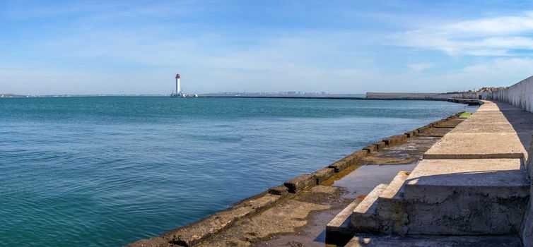 Lighthouse at the entrance to the harbor of Odessa seaport, on a sunny summer day