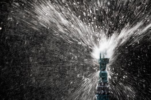 Close up view of sprinkler spraying water on blur background in garden.