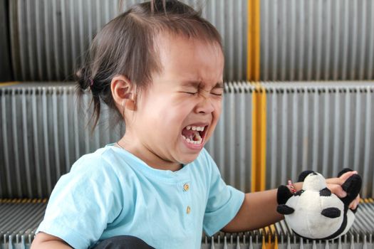 Child crying while falling on broken escalator background.