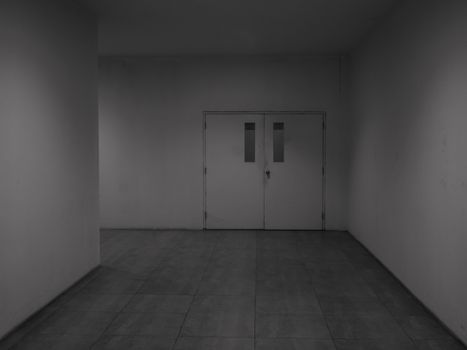 View of closed hospital doors at end of hallway. Dark & intimidating steel doors in hospital corridor.