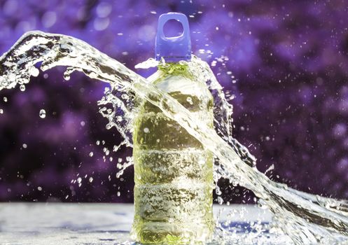 Fresh water splashing around of pure water bottle with blurred background. Selective focus and space for text.