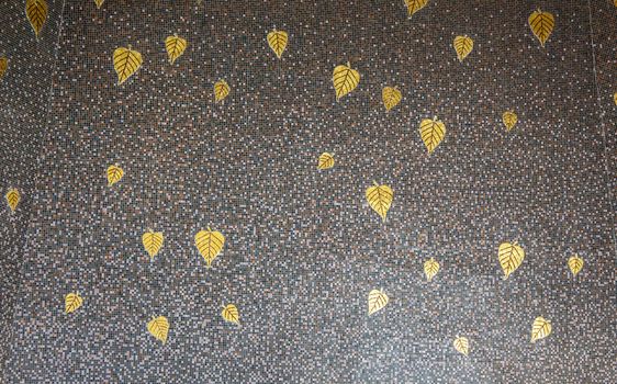 Gray marble patterned tiles decorated with golden Bodhi leaves.