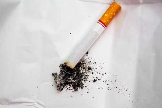 World No Tobacco Day; Cigarette with black ashes isolated on white background and space for text.