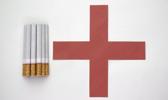 World No Tobacco Day; Heap of cigarettes with filter isolated on white background and Red cross symbol.