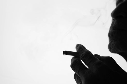 World No Tobacco Day; The silhouette of an elderly Asian man is smoking with space for idea text.