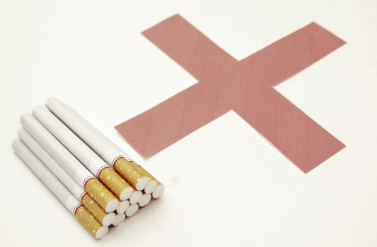World No Tobacco Day; Heap of cigarettes with filter isolated on white background and Red cross symbol.