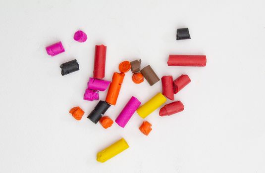 Broken crayons into small pieces isolated on white background.