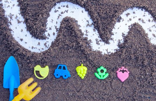 Children's beach toys - buckets, spade and shovel on sand with space for your texts. Concept of happiness on summer and fun of children.