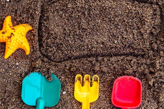 Toys put on sand at the beach with space for your texts. Concept of happiness on summer and fun of children.