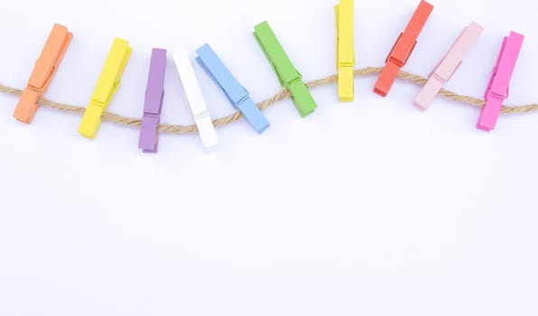 Color wooden clip on rope isolated on white background. This has clipping path. Frame and background concept.