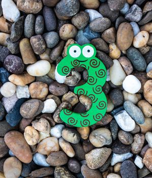 Pebbles pattern or small stones background in garden with colorful Arabic wooden numbers; 3. Concept of new year and textured.