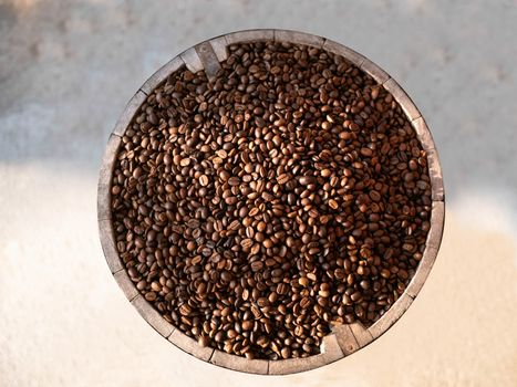 Coffee beans in a wooden barrels isolated on cement background, Top view.