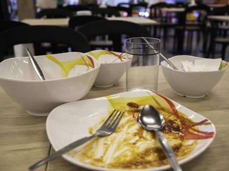 Dirty dishes on the table after lunch at food court in the mall. Dish ready for washing.