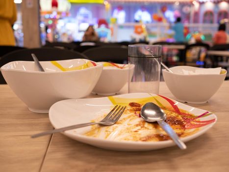 Dirty dishes on the table after lunch at food court in the mall. Dish ready for washing.