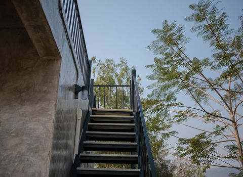 Stainless steel stairs outside the building with concrete wall.