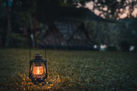 vintage lantern on the grass while camping in the evening