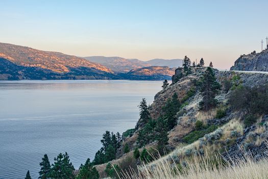 Scenery overview of Okanagan lake on summer sunset. Okanagan lake view with mountains on the background