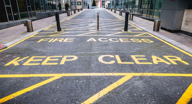 Dublin, Ireland - February 12, 2019: Fire Access Keep Clear with yellow paint on a path for firefighters in a high-tech district on a winter day