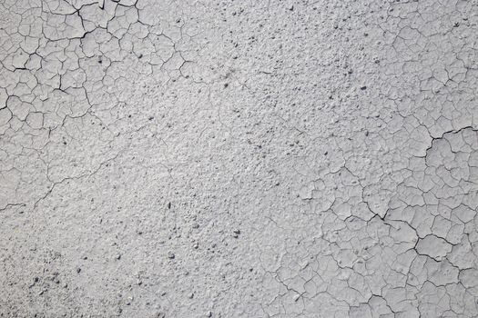 Dried cracked clay texture and gravel stones