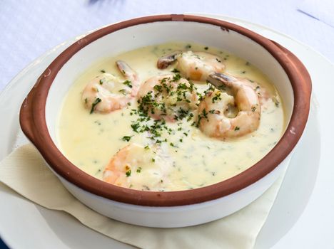 Ramekin of prawns with cream in plate