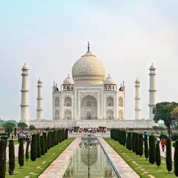 Taj Mahal front view reflected on the reflection pool, an ivory-white marble mausoleum on the south bank of the Yamuna river in Agra, Uttar Pradesh, India. One of the seven wonders of the world.