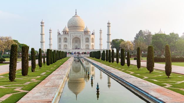 Taj Mahal front view reflected on the reflection pool, an ivory-white marble mausoleum on the south bank of the Yamuna river in Agra, Uttar Pradesh, India. One of the seven wonders of the world.