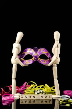 wood dummy with carnival mask in black background