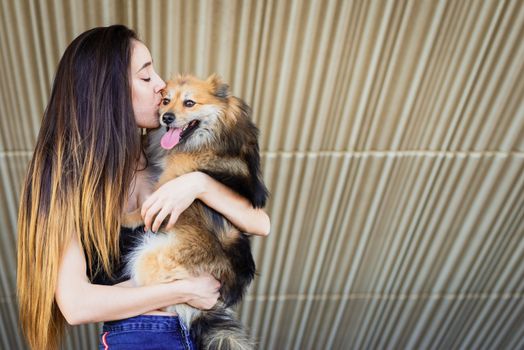 woman kissing dog with copy space for text