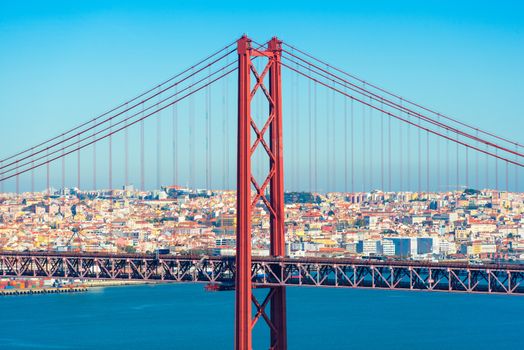 Lisbon, Portugal: The Bridge of 25th April with car traffic and panoramic view of the city on the background. Bridge structure up close
