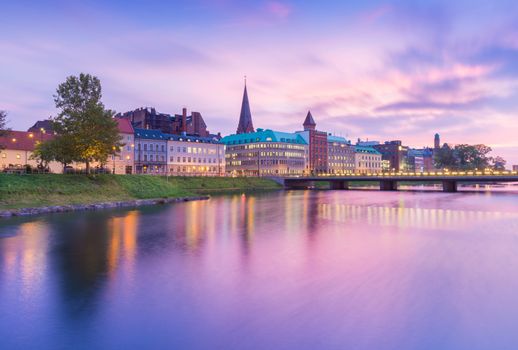 Beautiful sunset in Malmo, Sweden. Picturesque view of an old European city in the evening. Skyline reflected in the water. Long exposure photography