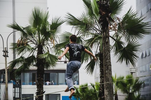 Man on rope jumping and doing balance