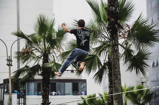 Man on rope jumping and doing balance