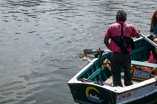Old man driving a boat at sea