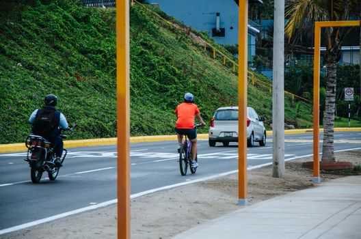 Motorcycle, bicycle and car along the coast of Miraflores beach, Lima - Peru