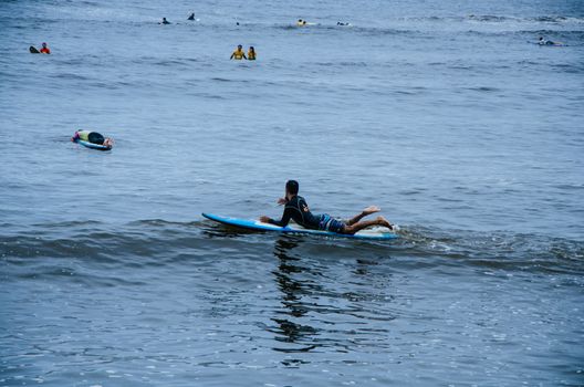 Surfer resting on his board in the sea