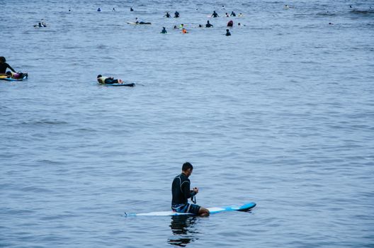 Surfer resting on his board in the sea