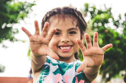 Happy girl showing her hands in the park