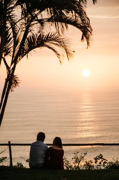 A couple in love sitting in front of the sea