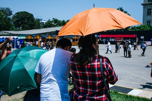 A couple with an umbrella protecting themselves from the sun