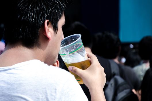 Man with a plastic cup with beer in his hand