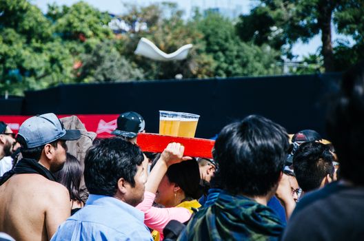 Two plastic cups with beer in a wooden box at a concert