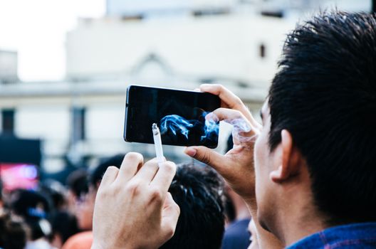 Man with cellphone and a cigar in his hand