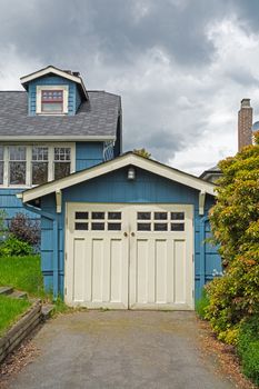 Detached single stall garage on front yard of residential house.