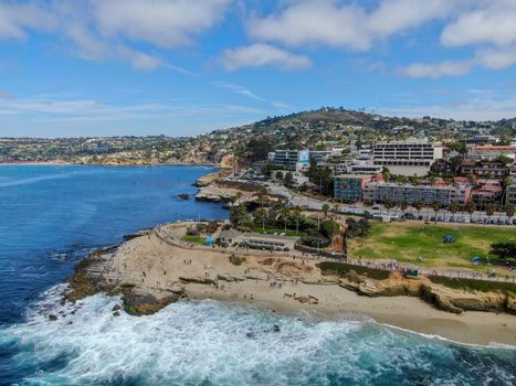 Aerial view of La Jolla coast, San Diego, California. Beach and blue sea with small waves. Hilly seaside of curving coastline along the Pacific.