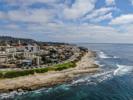 Aerial view of La Jolla coast, San Diego, California. Beach and blue sea with small waves. Hilly seaside of curving coastline along the Pacific.