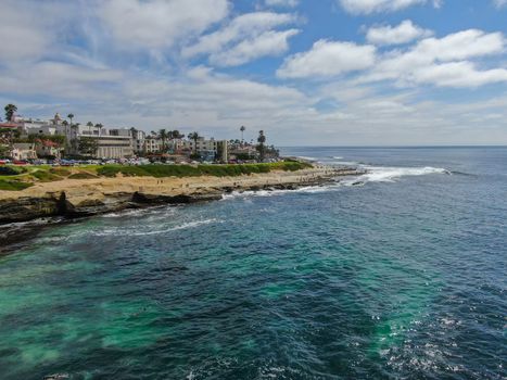 Aerial view of La Jolla coast, San Diego, California. Beach and blue sea with small waves. Hilly seaside of curving coastline along the Pacific.