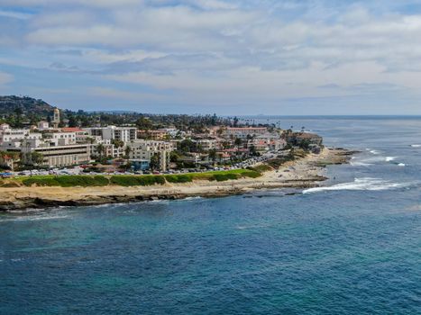 Aerial view of La Jolla coast, San Diego, California. Beach and blue sea with small waves. Hilly seaside of curving coastline along the Pacific.