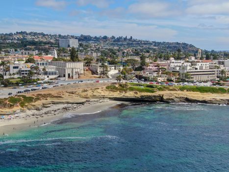 Aerial view of La Jolla coast, San Diego, California. Beach and blue sea with small waves. Hilly seaside of curving coastline along the Pacific.