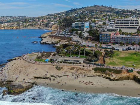 Aerial view of La Jolla coast, San Diego, California. Beach and blue sea with small waves. Hilly seaside of curving coastline along the Pacific.